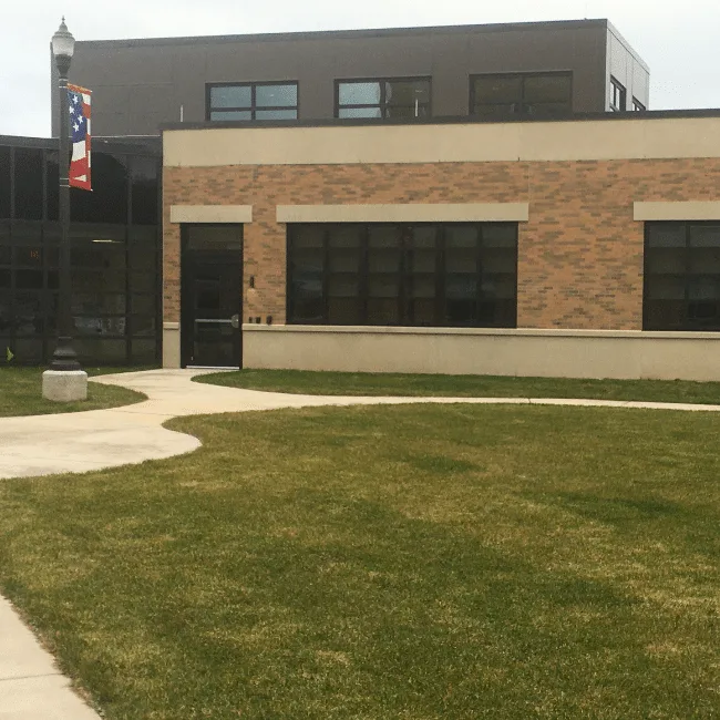 Two-story brick and cast-stone building featuring a prominent curtain-wall entry, Hines, IL