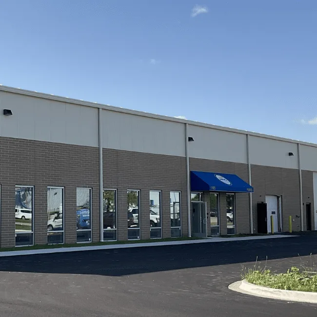 Single-story manufacturing facility with a blue entry awning, built for proprietary production processes, Wauconda, IL