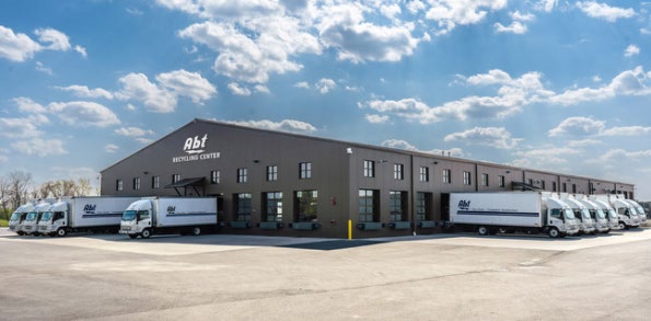 Single storey recycling facility with loading docks and two Abt box trucks parked outside in Glenview, Illinois