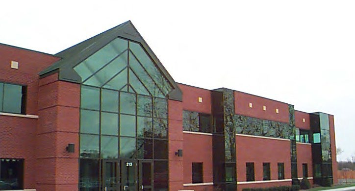 Brick and glass office building entrance with a curved green roof in McHenry, Illinois