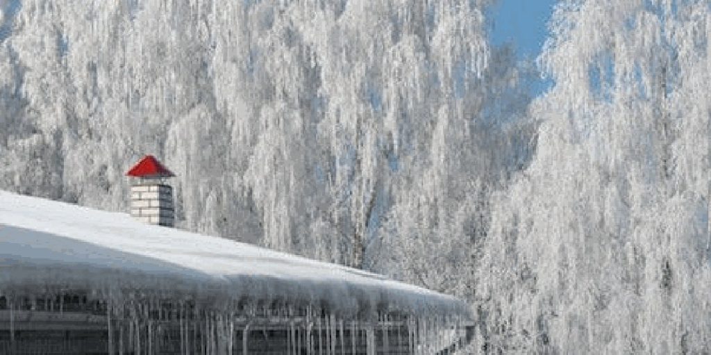 Snow and ice built up along a roof edge after a heavy winter storm