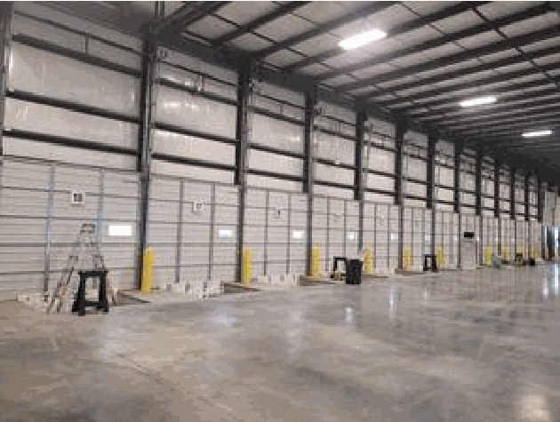 Completed warehouse interior with a long row of loading dock doors