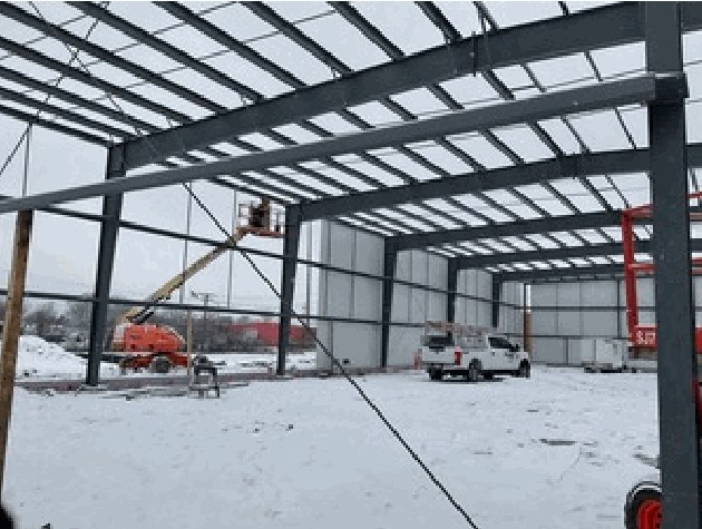 Interior of a partly erected steel building with snow on the ground outside