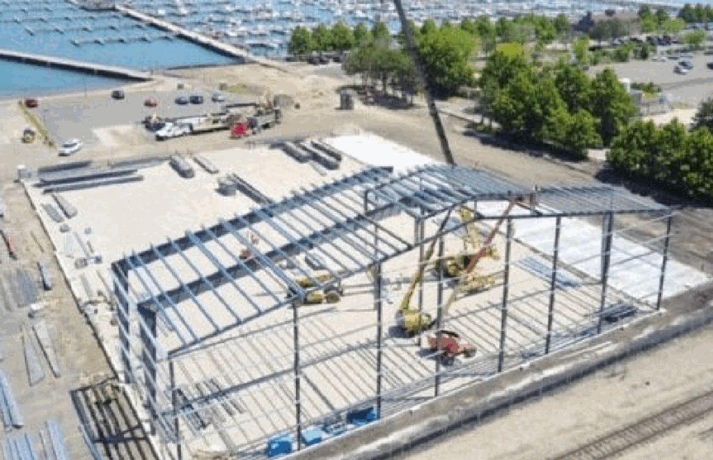 Aerial view of a steel building frame under erection with cranes working on site