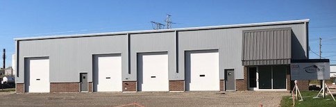 Rebuilt metal building with three white overhead doors after fire damage repair in Gurnee, Illinois
